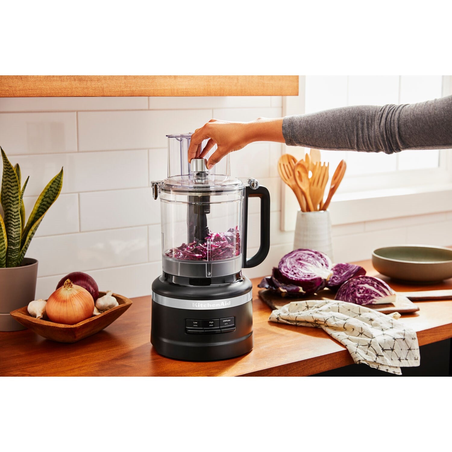 Black matte food processor with clear work bowl and central blade attachment