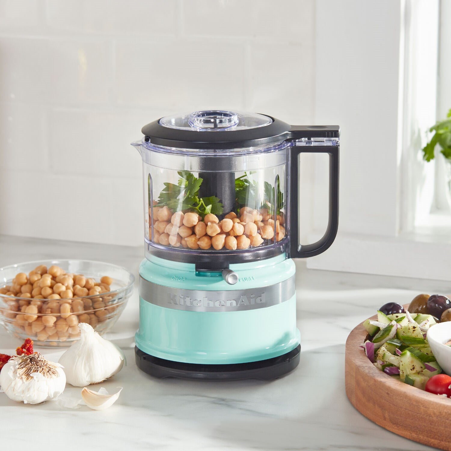 KitchenAid 3.5-cup food chopper, ice-blue base, clear bowl filled with chopped ingredients