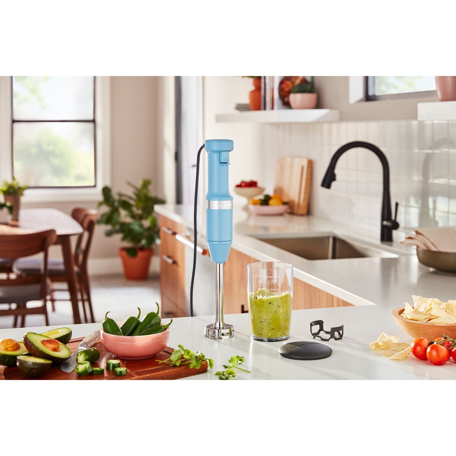 Blue immersion blender blending in a blending jar cup