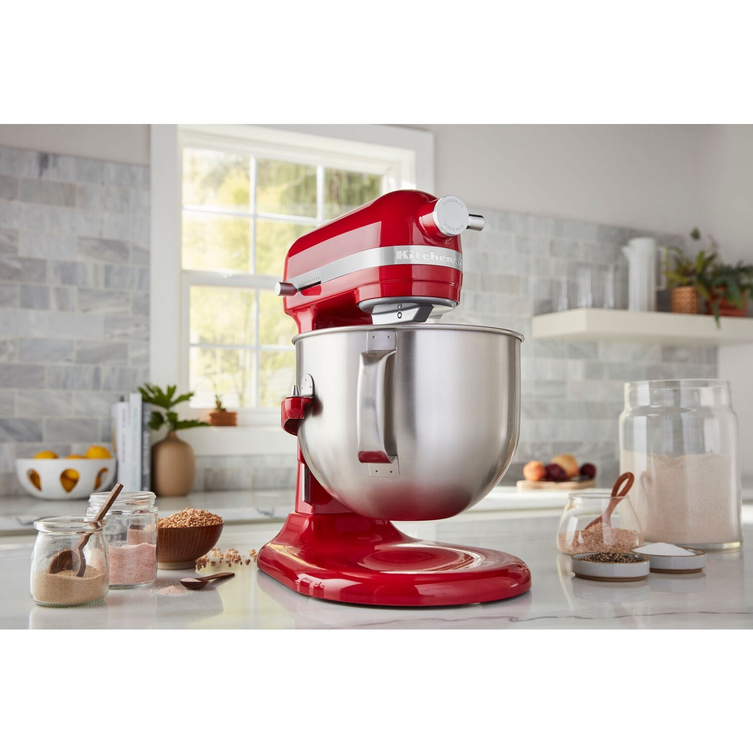 Candy red stand mixer with stainless mixing bowl on countertop