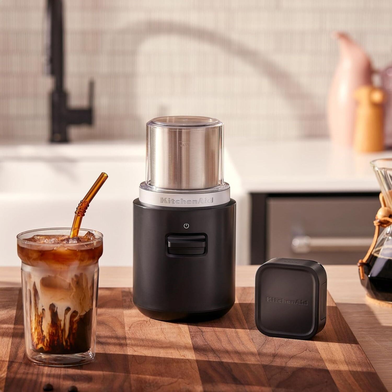 Black matte cordless coffee grinder with stainless top, plus removable control cover