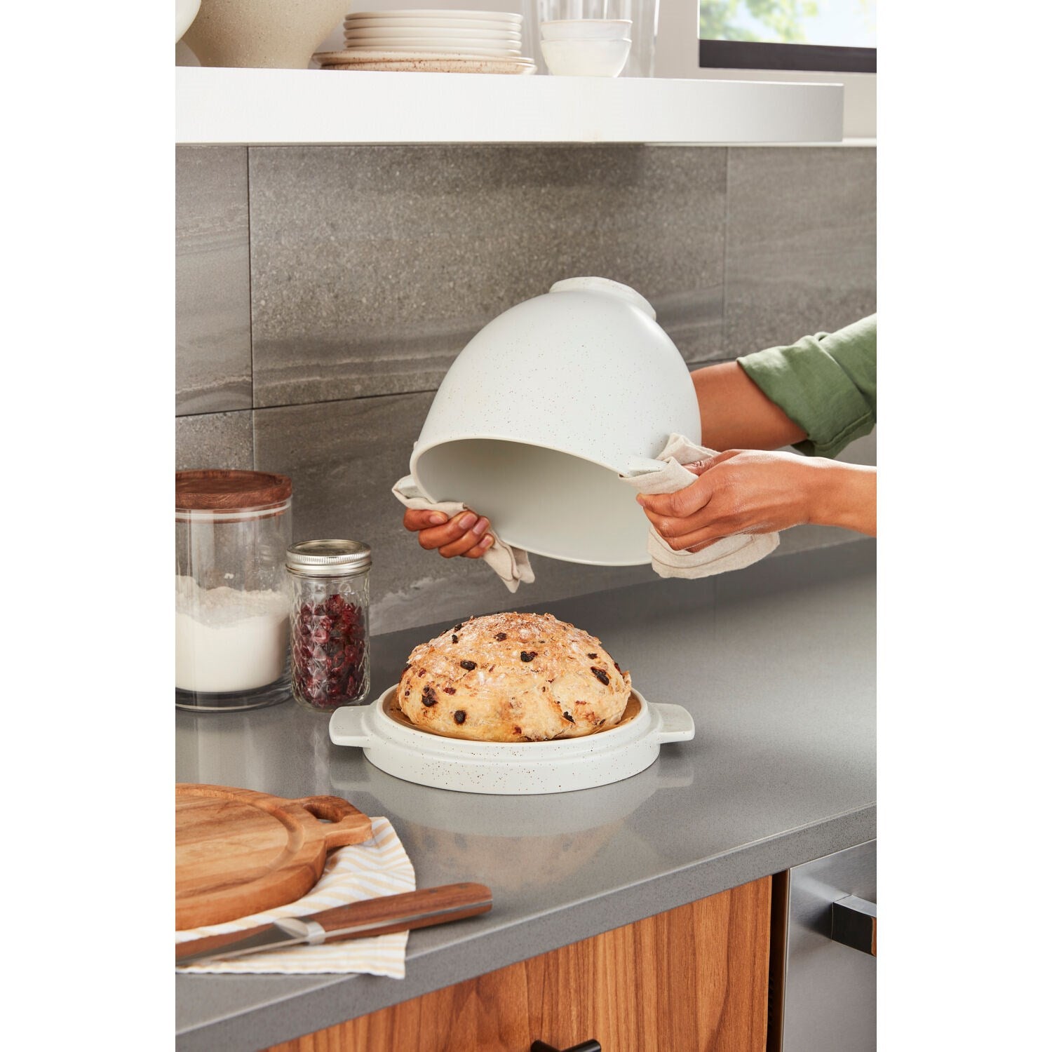 Bread baking bowl and lid, light speckled ceramic, on countertop with bread