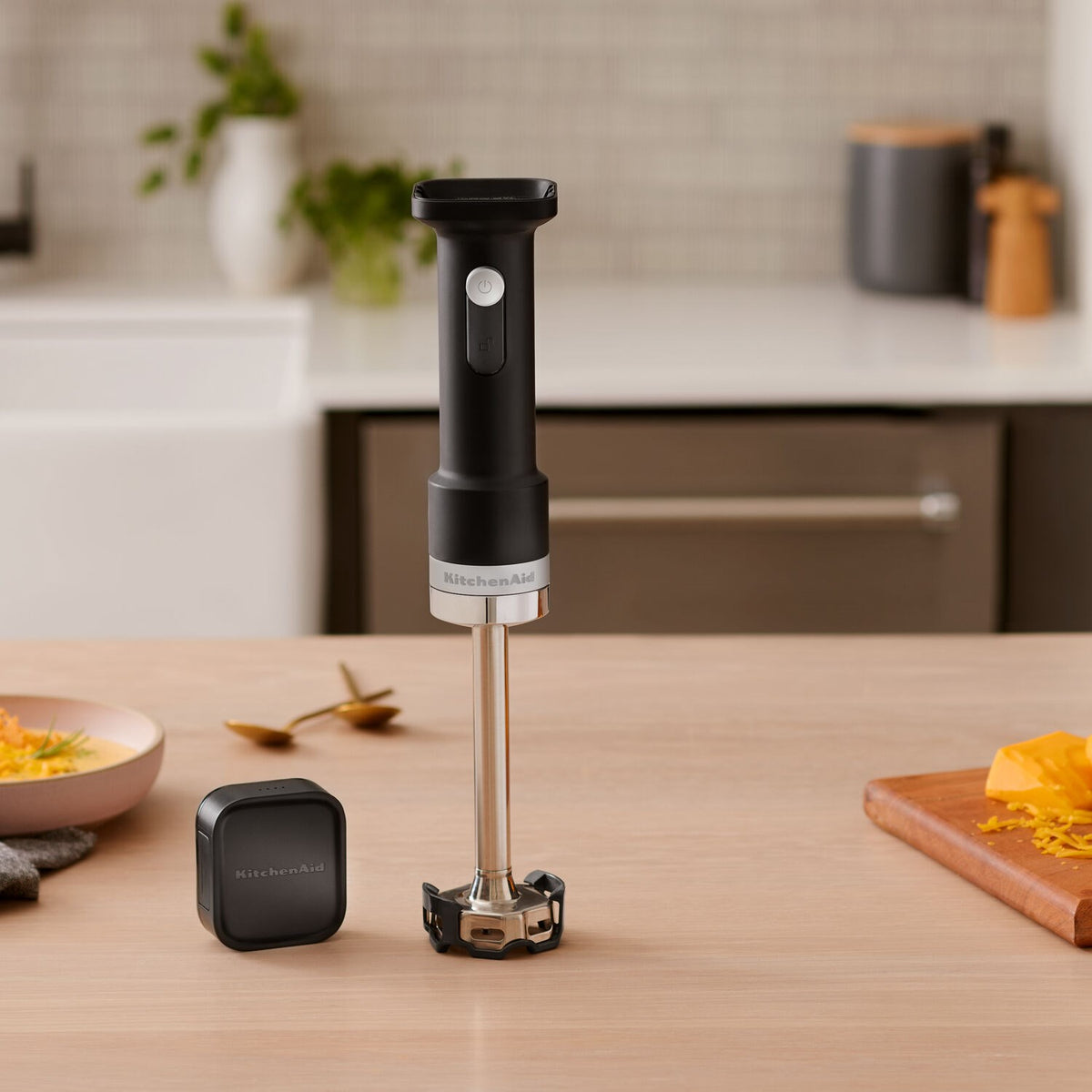 KitchenAid cordless hand blender with removable battery, standing on base