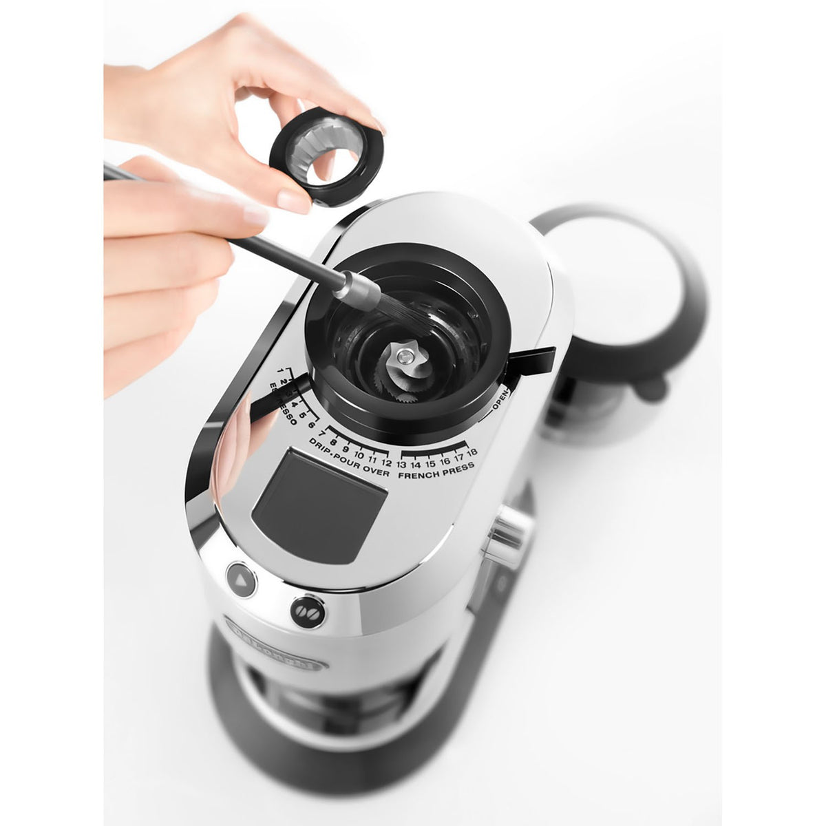 De'Longhi Dedica coffee grinder with hand adjusting the top control knob