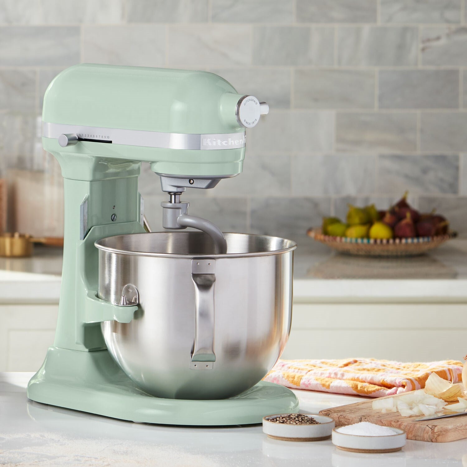 Pistachio stand mixer with stainless bowl and paddle attachment on bowl lift base