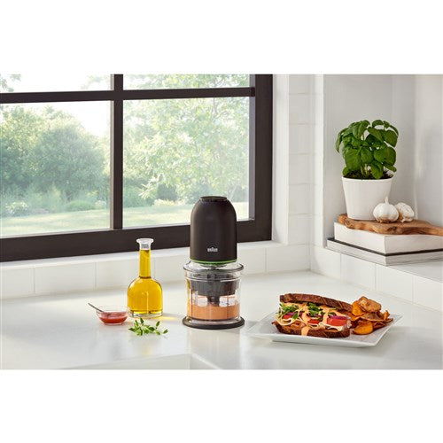 Black mini food chopper with clear bowl and dark blade hub, on kitchen counter