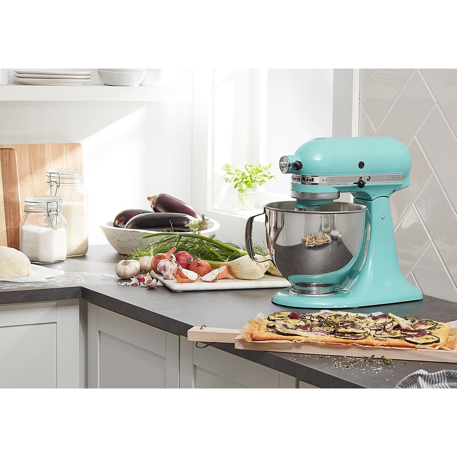Blue aqua tilt-head stand mixer on kitchen counter with stainless bowl and prepared dough