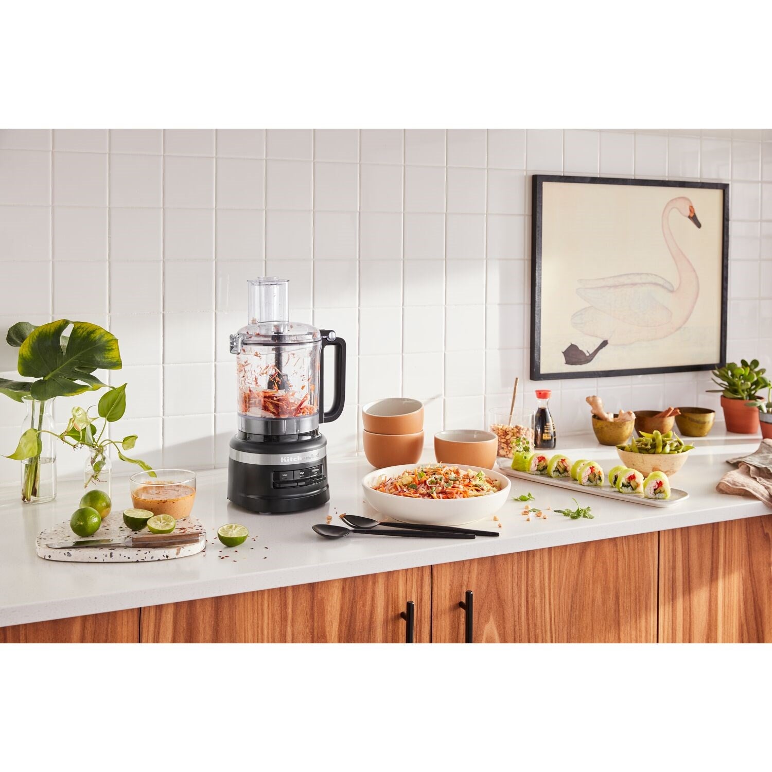 Black-and-clear food processor on countertop with accessories and dish bowl