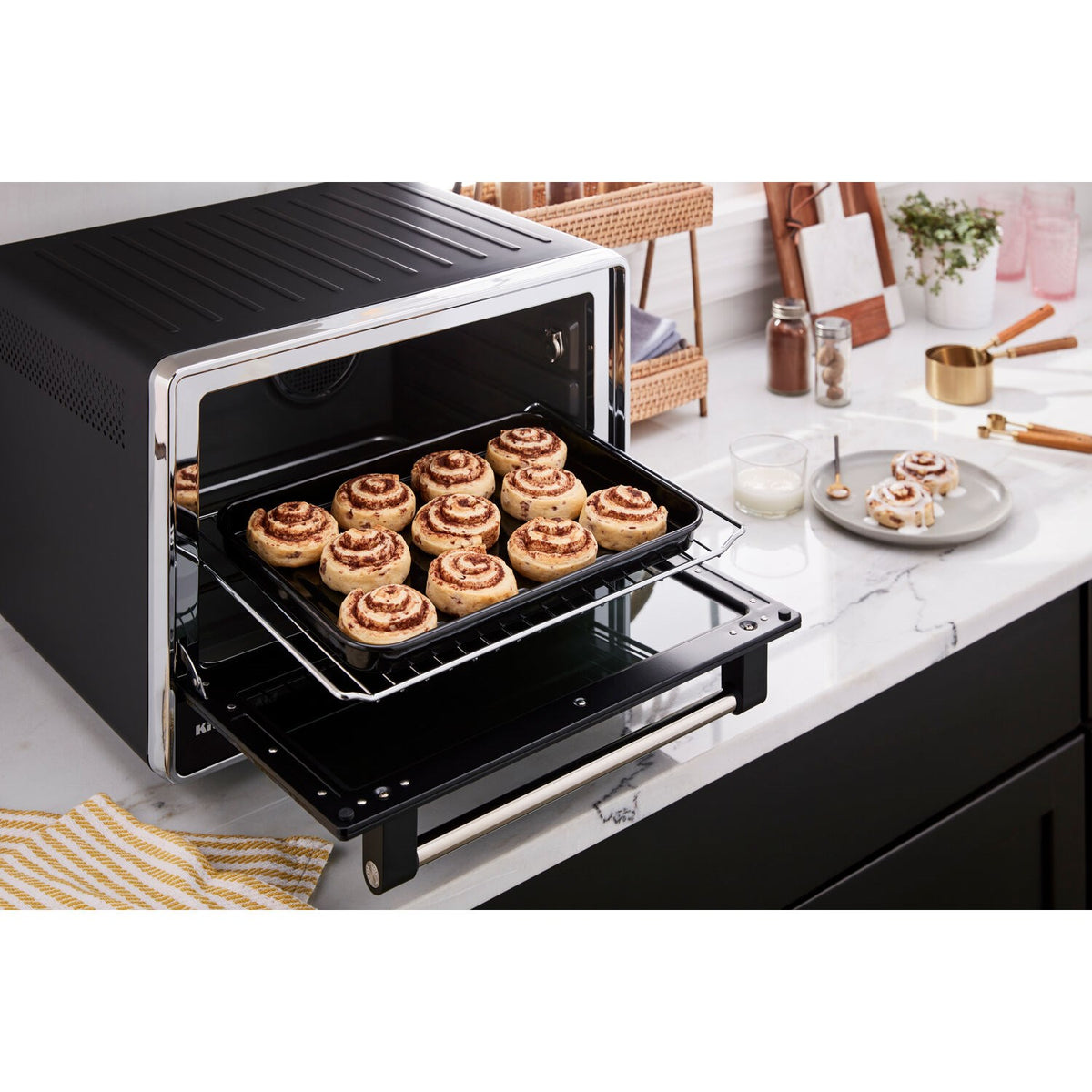 Countertop oven open with tray of golden-brown rolls on a wire rack