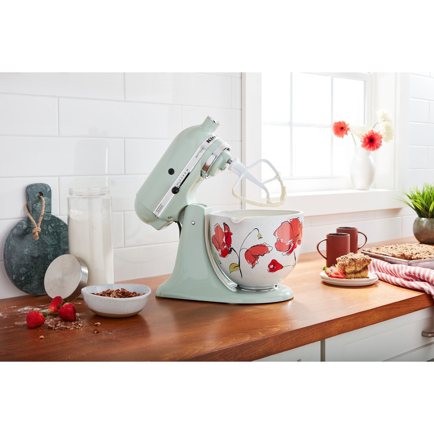Pistachio tilt-head stand mixer on countertop with whisk attachment