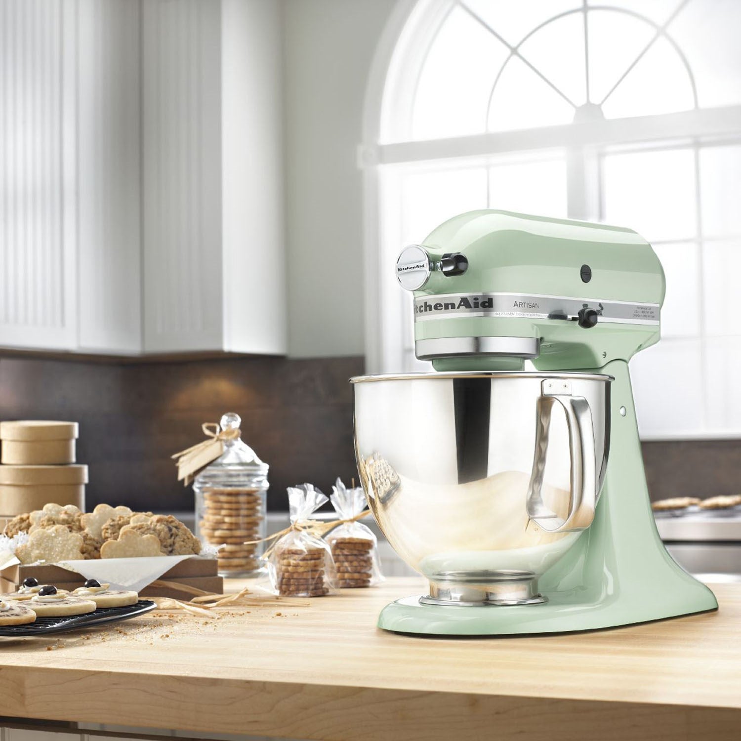 Pistachio tilt-head stand mixer with stainless bowl and beater, on kitchen counter