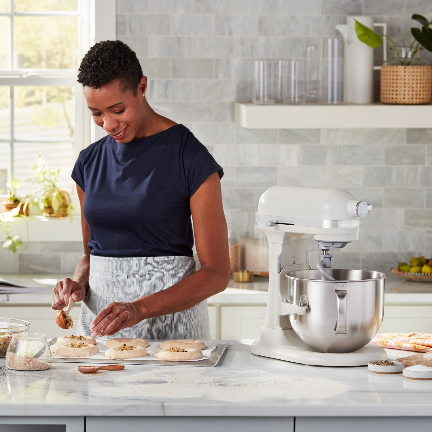 Cream stand mixer on countertop with stainless steel bowl