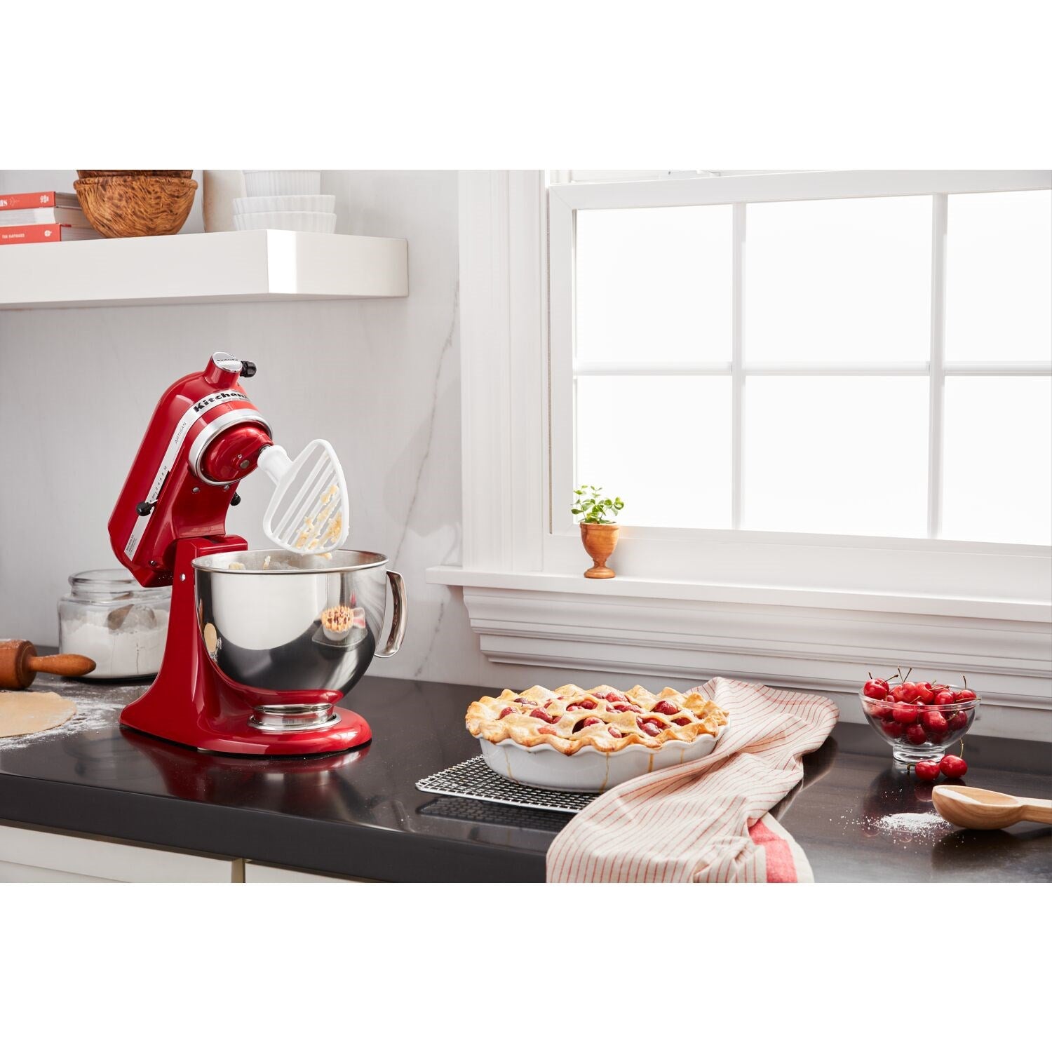 Empire red KitchenAid stand mixer with stainless bowl on kitchen counter