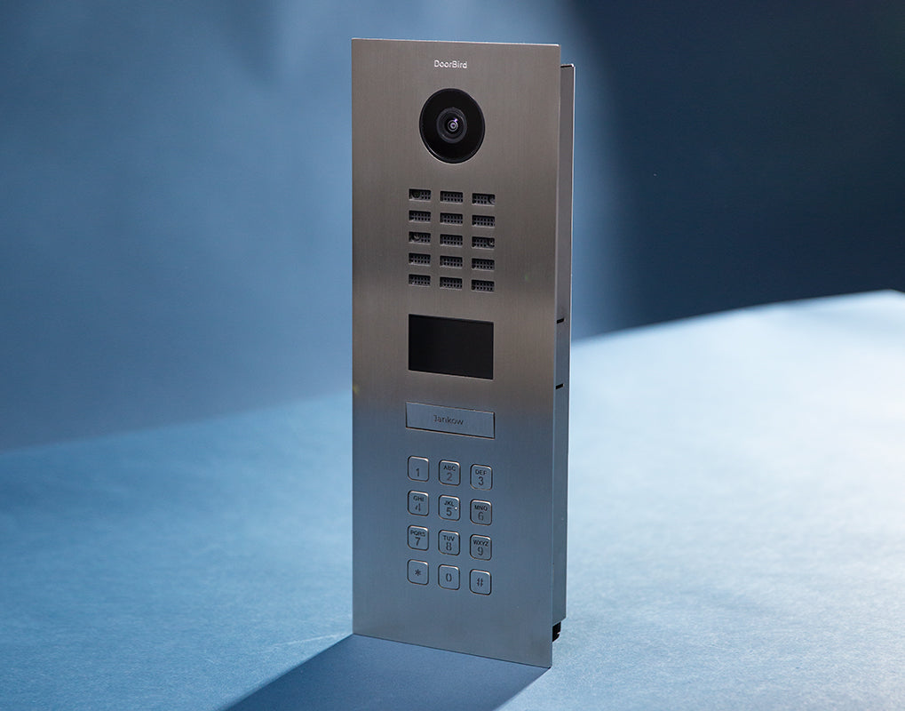 DoorBird video door intercom call panel with camera, speaker grille, and keypad on stand