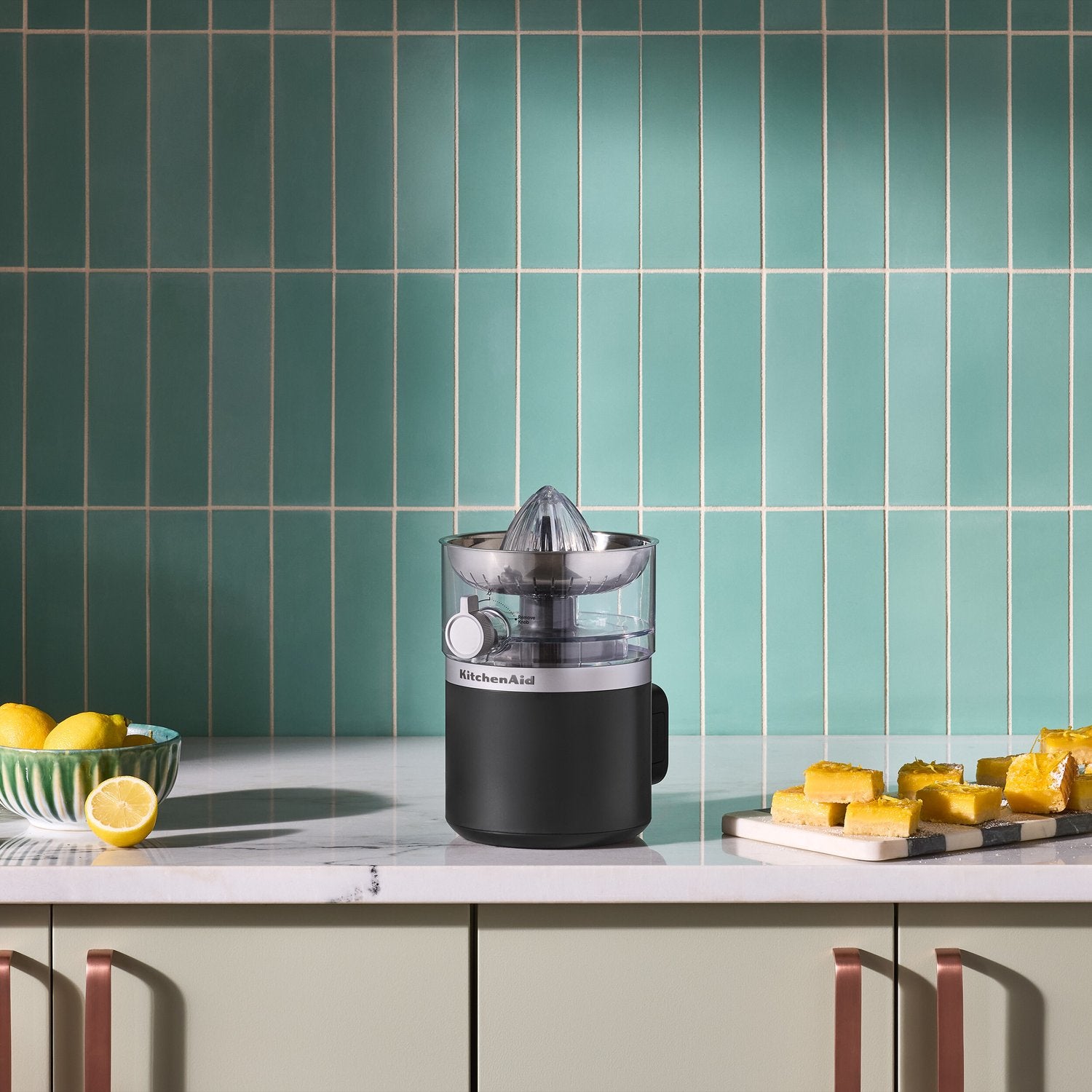 Compact black matte cordless citrus juicer with stainless reamer cone on countertop