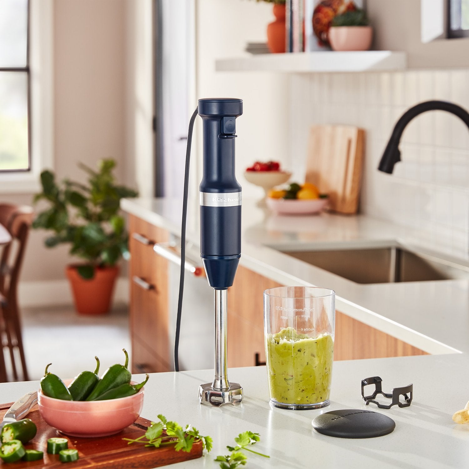 Ink blue immersion blender over blending jar on kitchen counter