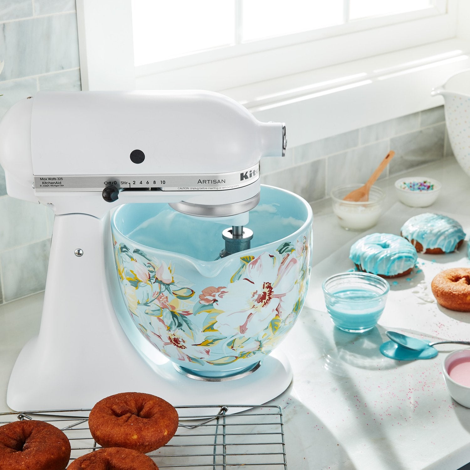 Ceramic mixing bowl with colorful floral pattern and light blue interior on mixer