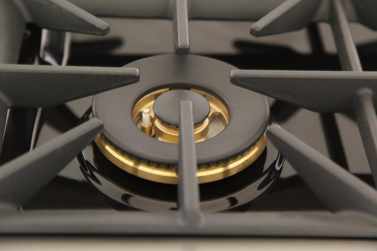 Gas burner head with dark grates and brass ring detail