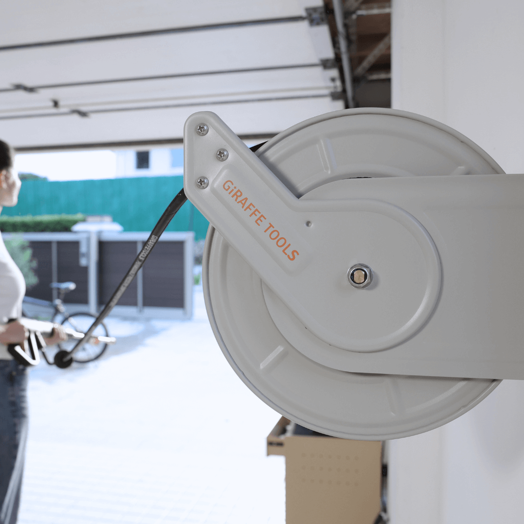 Close-up of wall-mounted pressure hose reel drum with coiled hose and metal arm