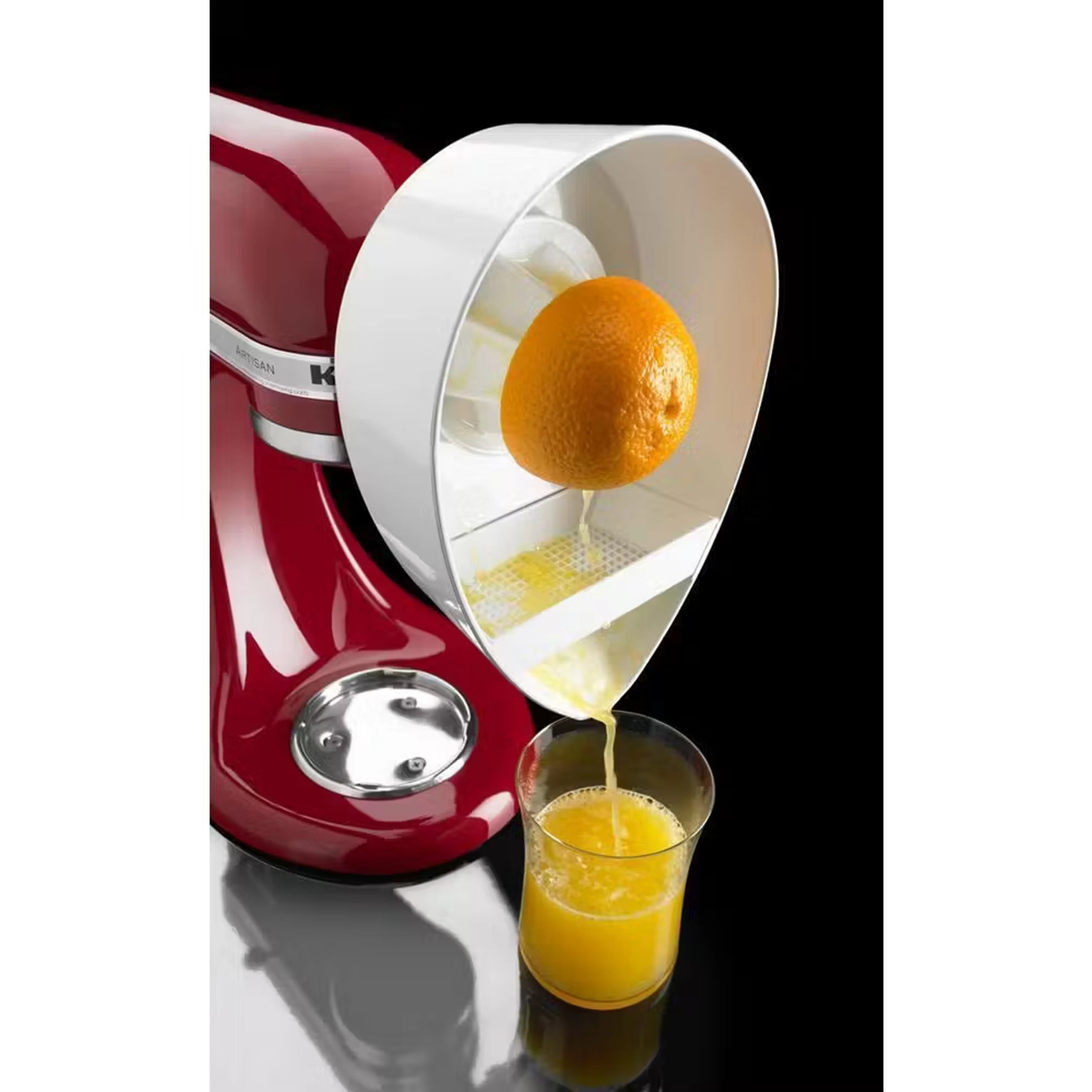 Citrus juicer attachment dispensing orange juice into cup from stand mixer.