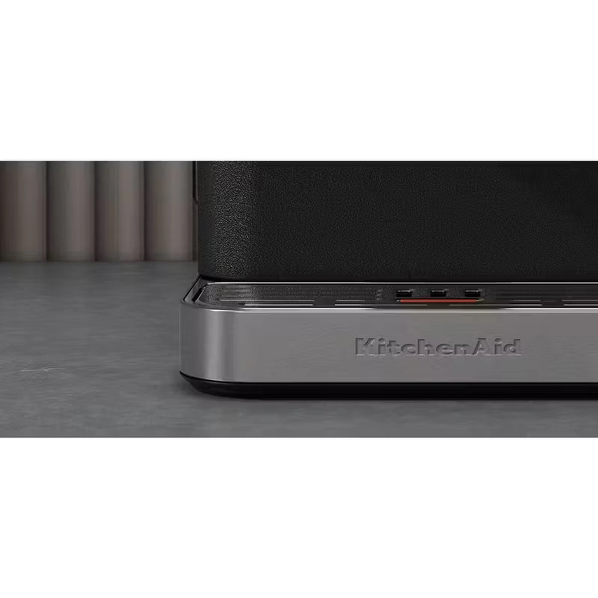 Stainless base of black espresso machine with KitchenAid logo and indicator lights.