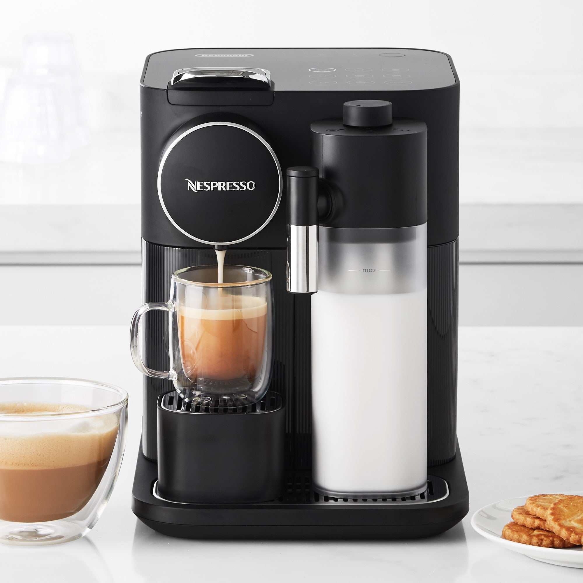 Black espresso machine pouring coffee into mug with attached milk frother