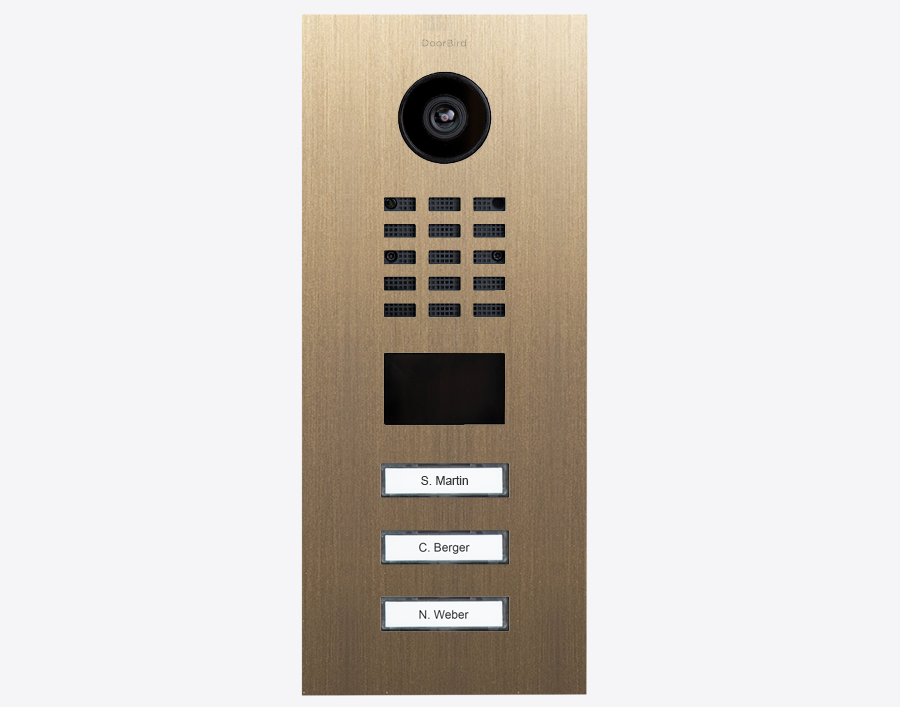DoorBird IP video door station in burnished brass with camera lens and 3 call buttons
