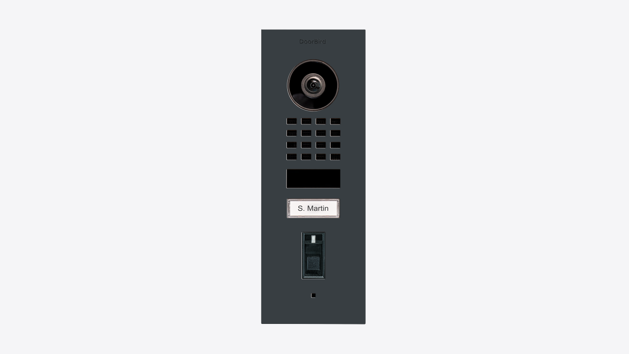 DoorBird flush-mount video door station, dark grey front with camera, speaker grille, nameplate