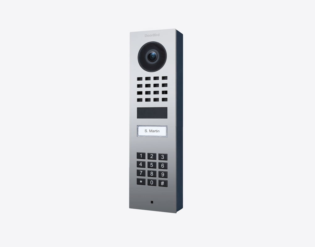 DoorBird surface-mount video door station with camera lens, keypad, and call button, dark metal