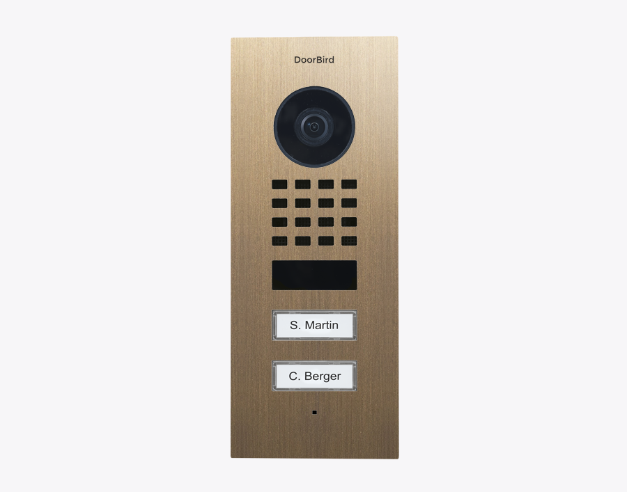DoorBird flush-mount video door station front in burnished brass with camera and two call buttons