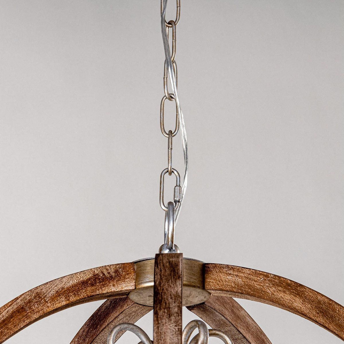 Top connection of brown circular pendant with metal chain and mounting bracket