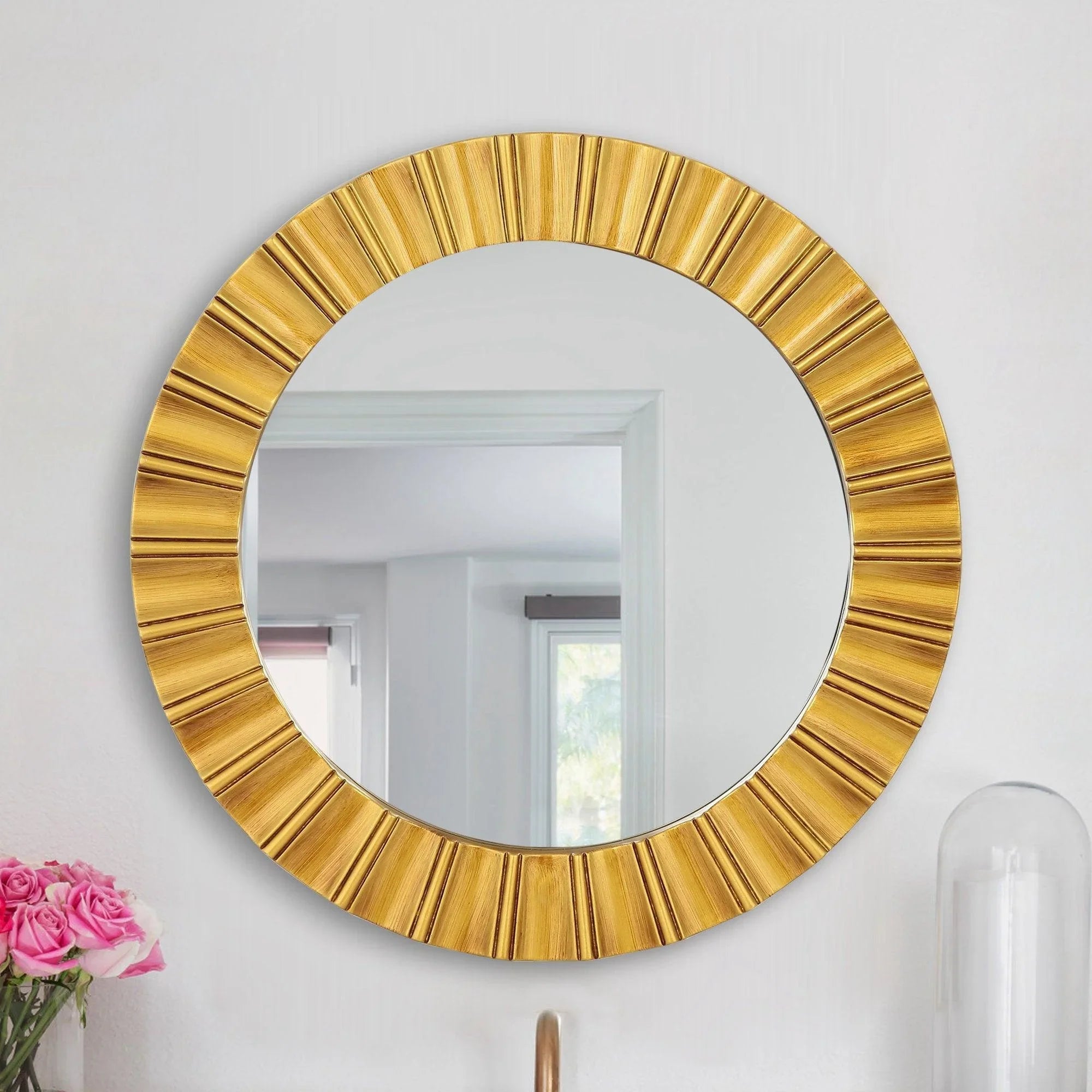 Golden round wall mirror with ribbed sunburst frame and reflective glass center