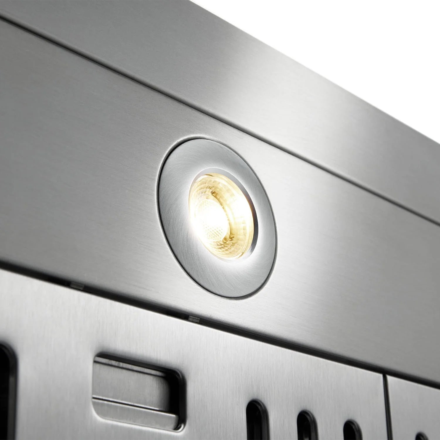 Stainless steel range hood control light bezel with illuminated bulb.