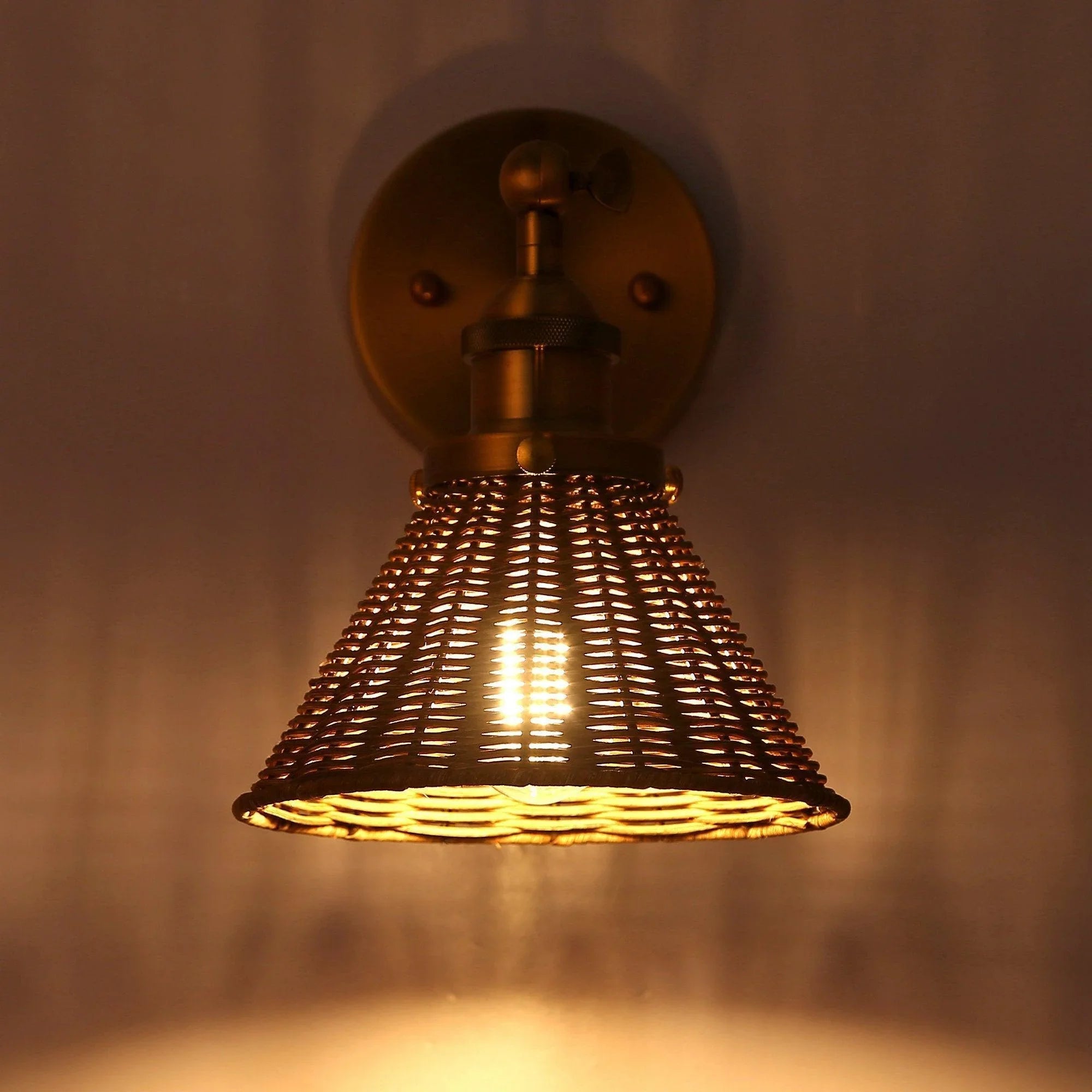 Golden wall light with woven rattan cone shade glowing from the inside