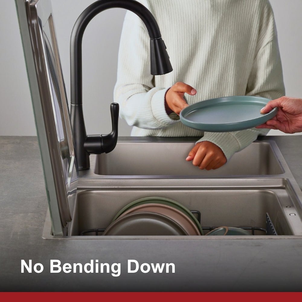 In-sink dishwasher with open tub and person placing a light blue plate