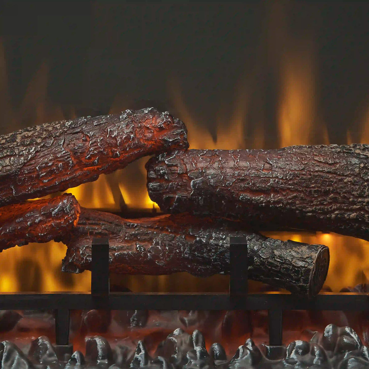Electric fireplace logs with glowing orange flames behind a black firebox grate