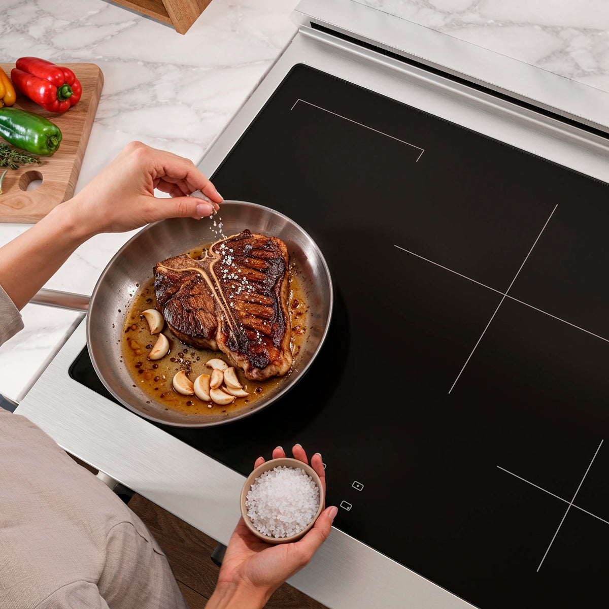 Induction cooktop with black glass surface and skillet cooking food