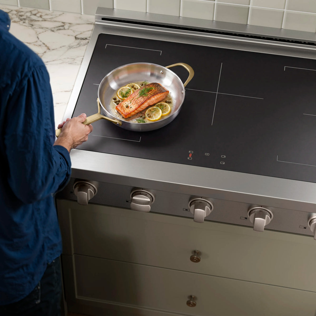 Stainless induction cooktop with matte black glass and pan of food
