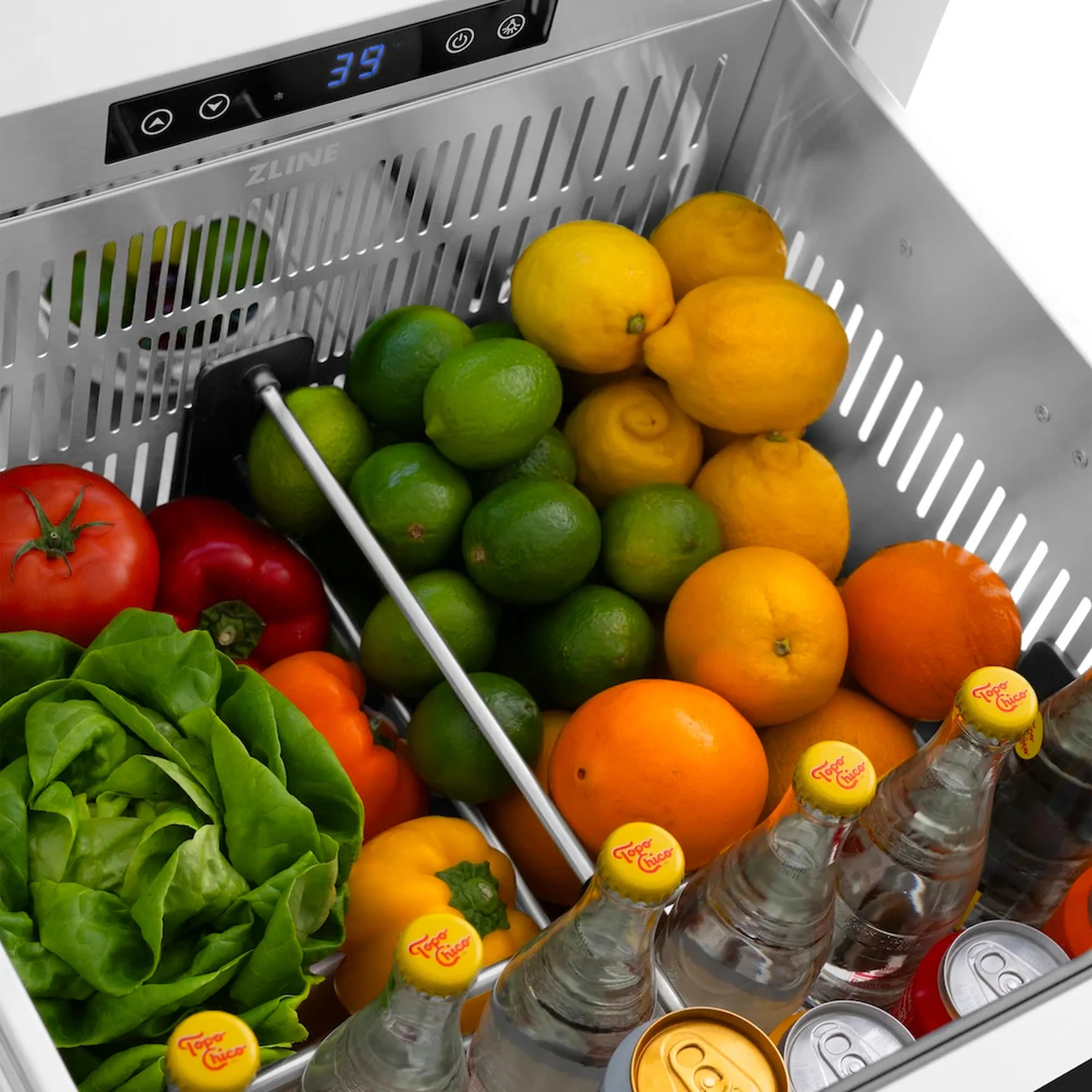 Stainless refrigerator drawer interior with lemons, limes, oranges, tomatoes, and bottles