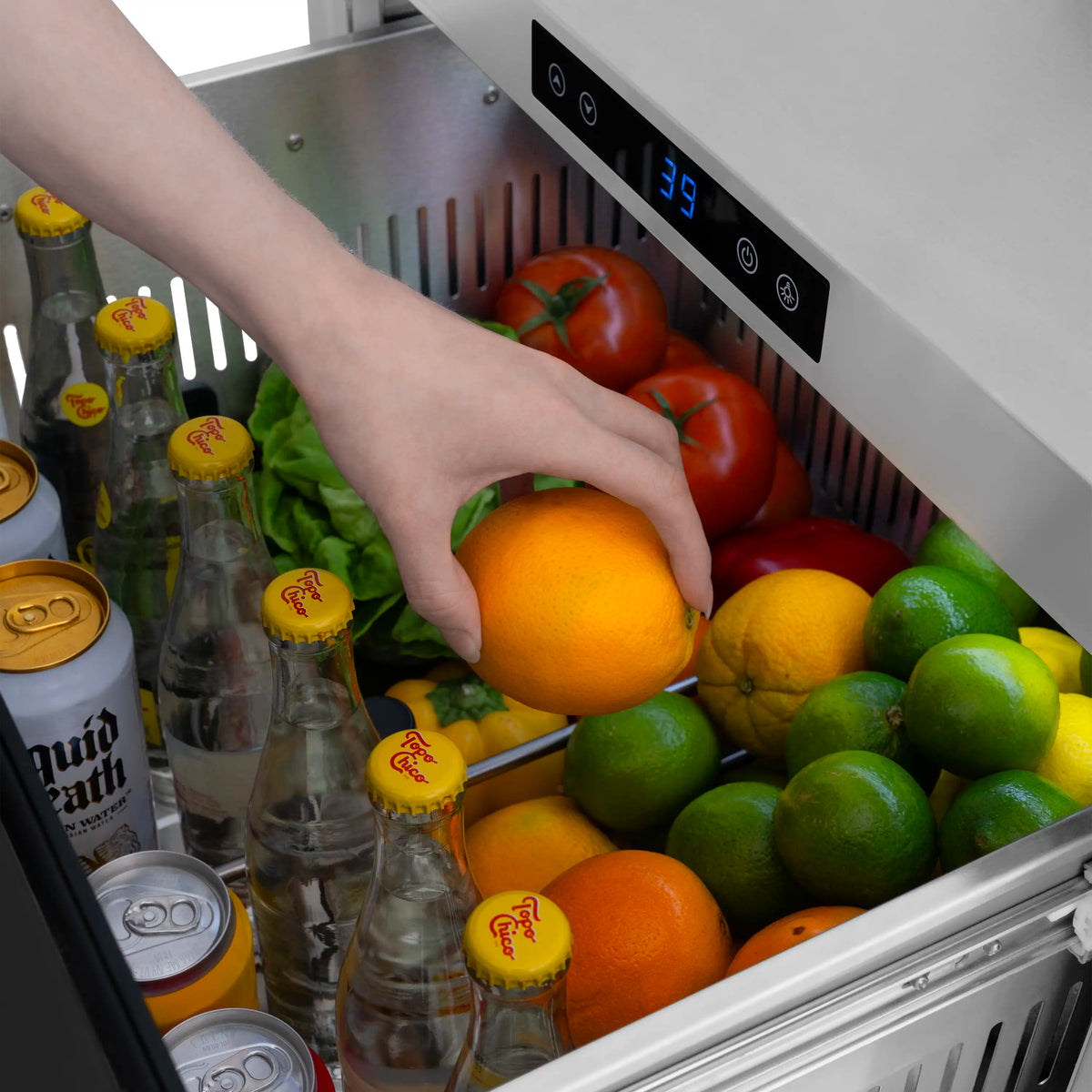 Refrigerator drawer interior with fruit and vegetables; hand reaching inside