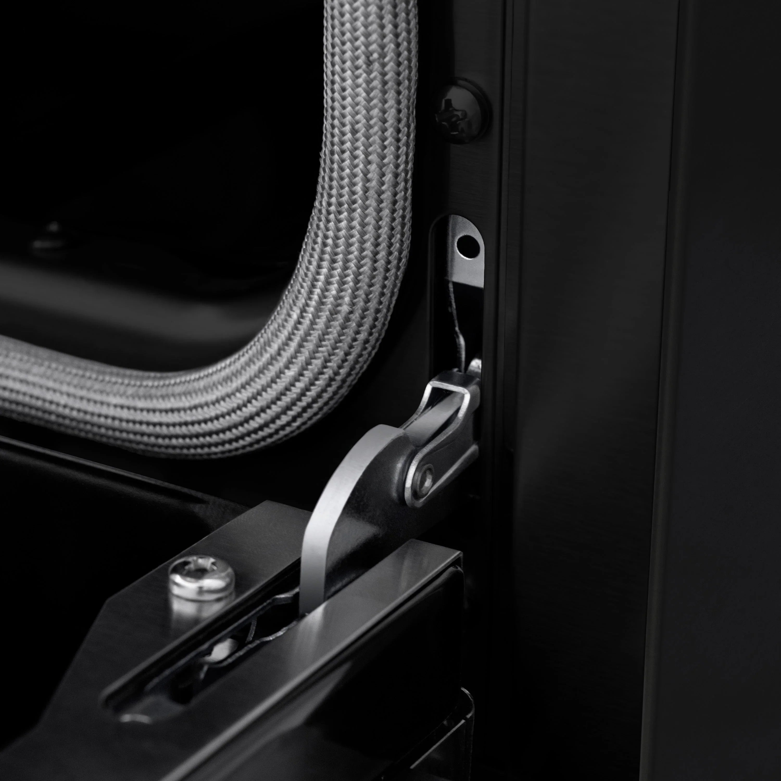 Black oven door handle with stainless accents and flexible power conduit