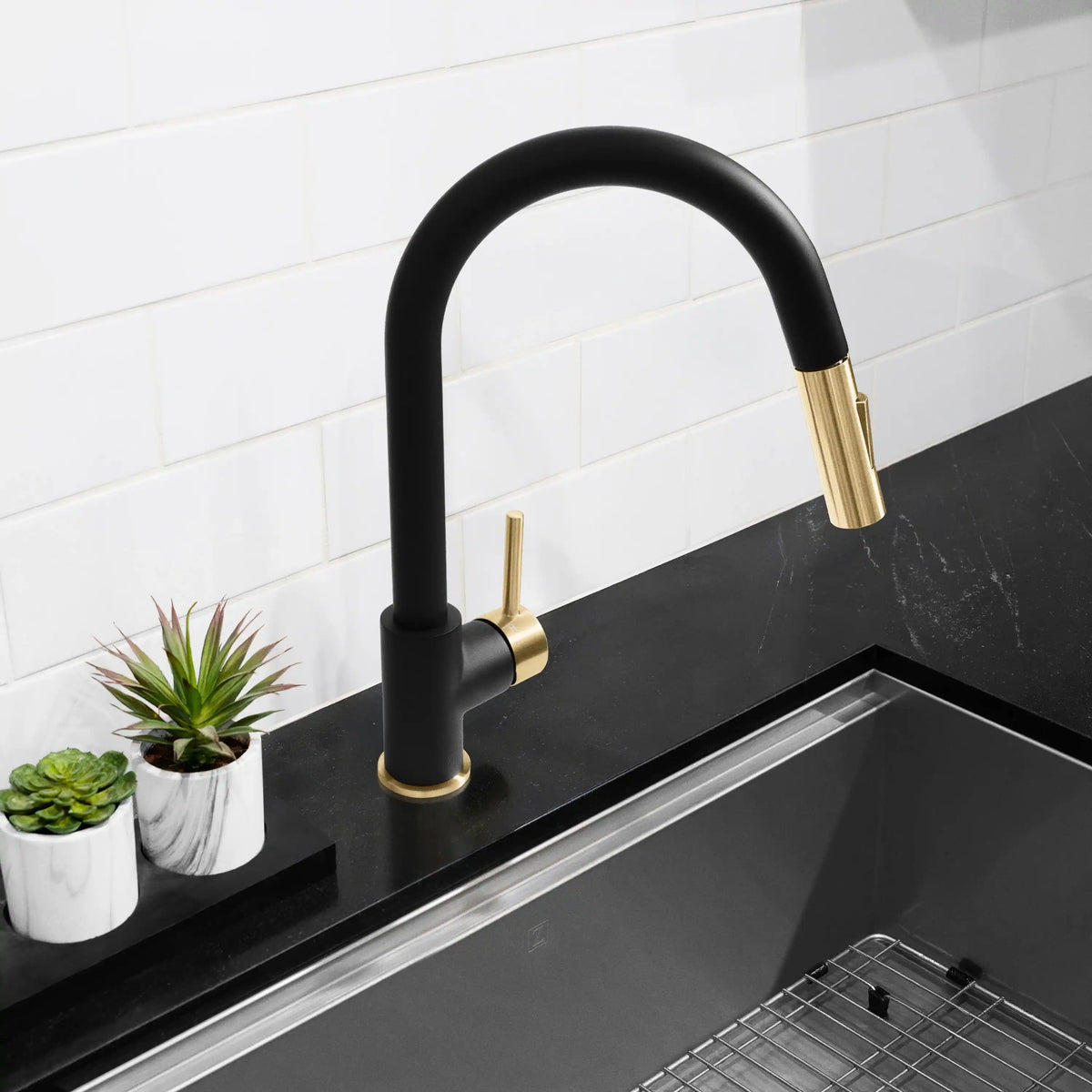 Matte black kitchen faucet with champagne bronze lever and curved spout over sink