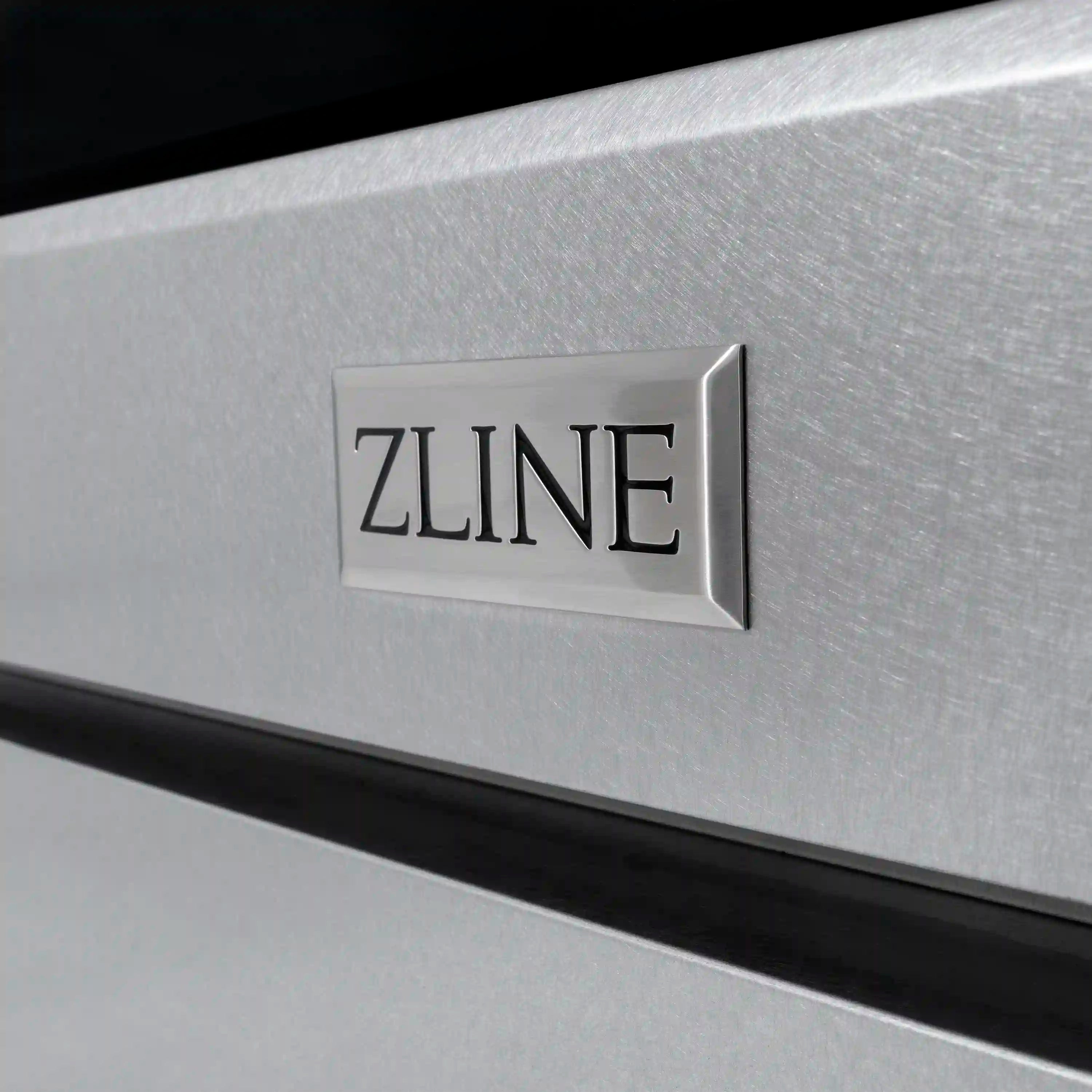 Satin stainless steel ZLINE range front panel with mounted brand logo and matte black trim.