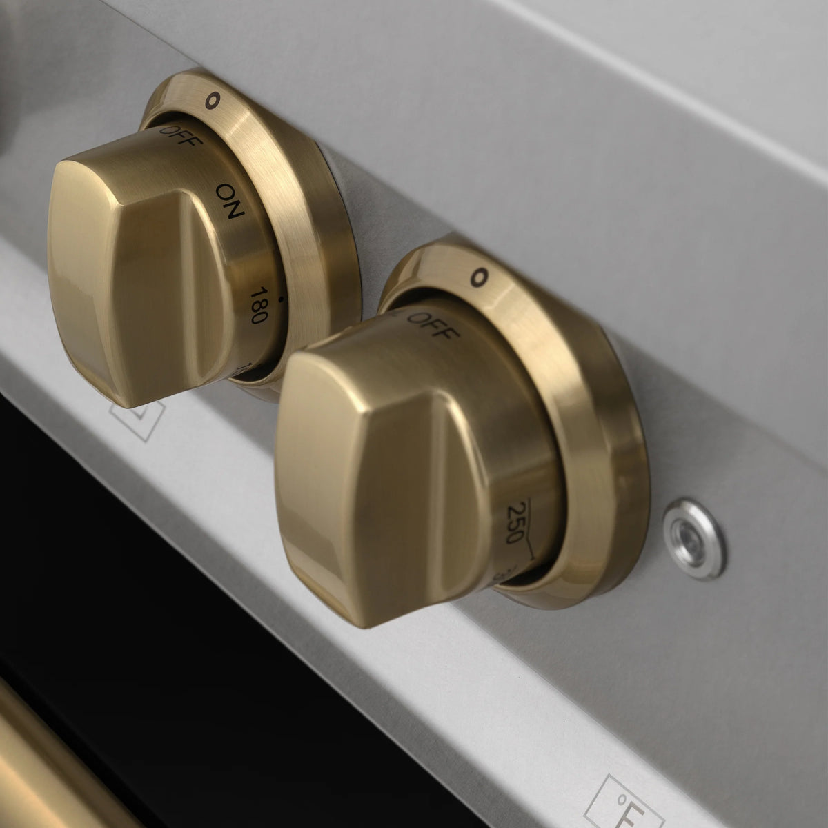 Stainless control panel with two champagne bronze knobs labeled OFF