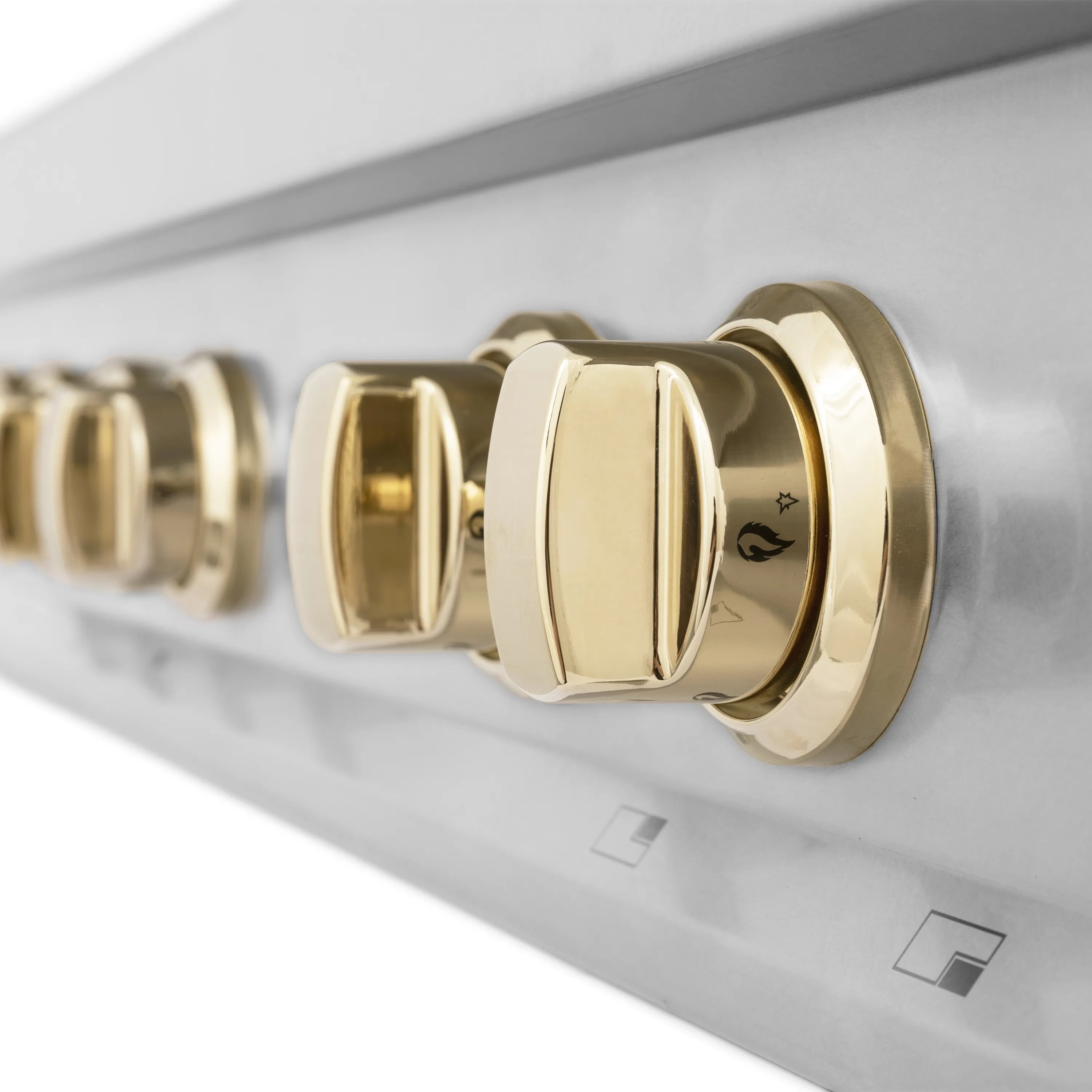 Gold control knob on stainless steel gas rangetop with burner settings markings.
