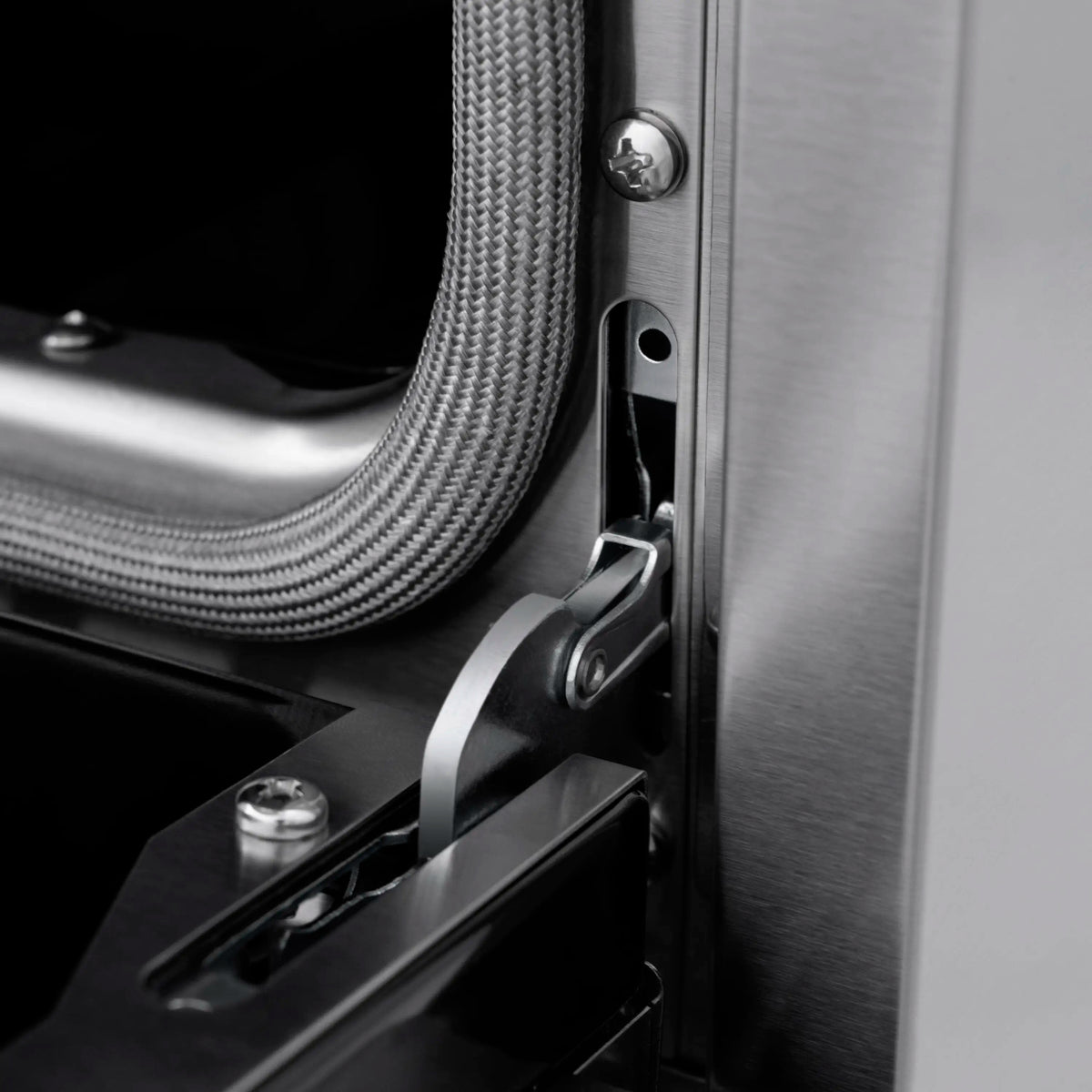 Stainless gas range side detail with flexible gas line and metal bracket