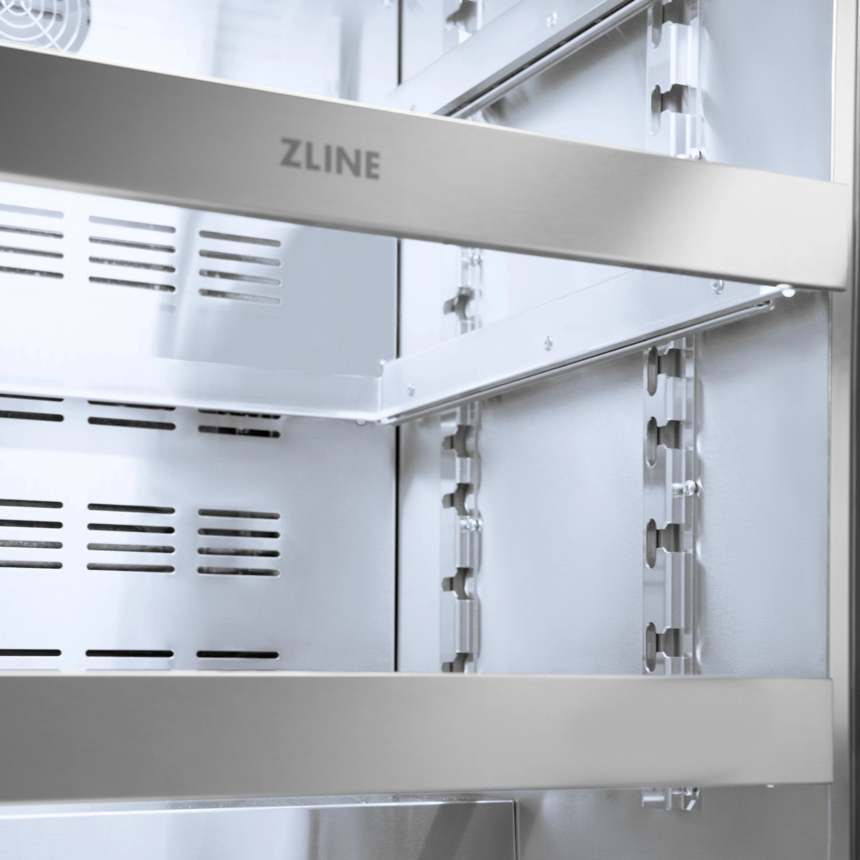 Stainless steel beverage fridge interior with wire shelves and side brackets