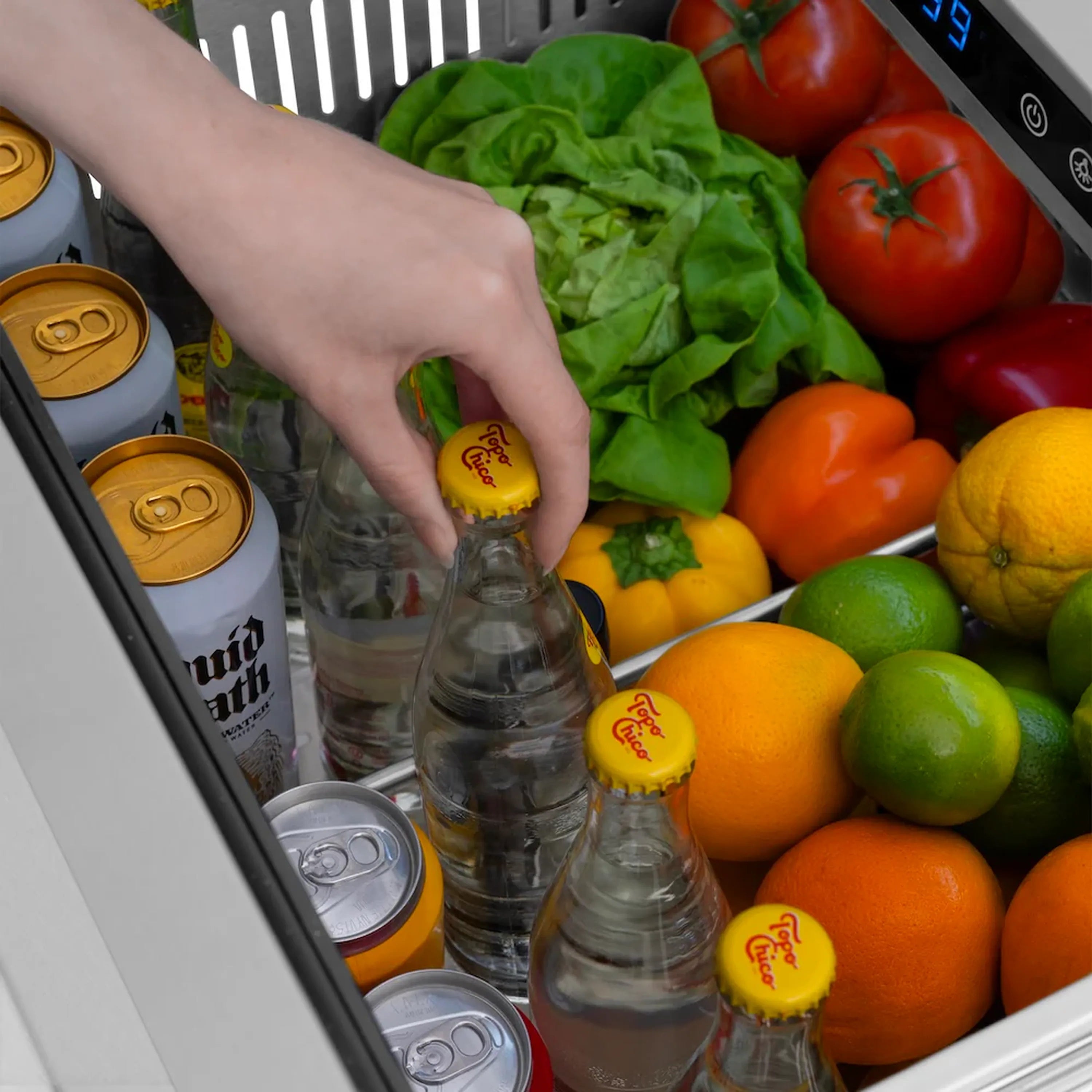 Refrigerator drawer with hand reaching bottles; mixed produce and gold can tops inside