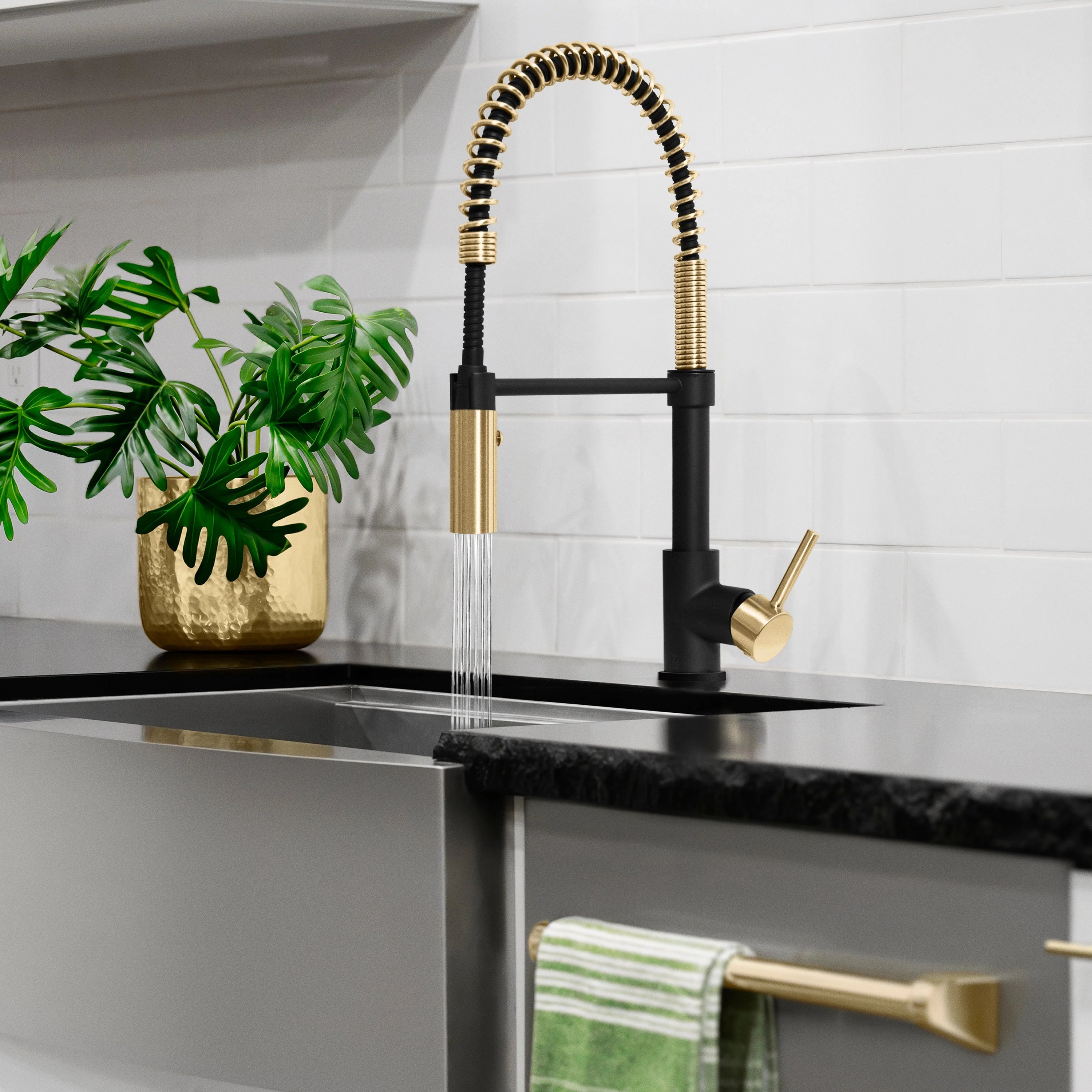 Single-handle pull-down kitchen faucet with matte black body and champagne bronze sprayer hose