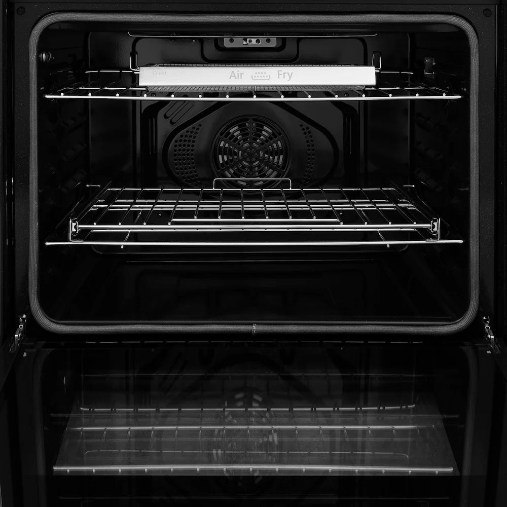 Empty stainless steel oven cavity with air fry tray and wire rack